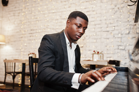 Strong powerful african american man in black suit play piano.の写真素材