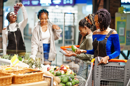 Group of african womans with shopping cart buying exotic fruits in grocery store supermarket.の写真素材