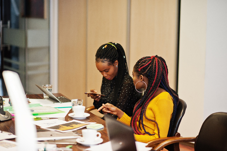 African american women colleagues, crew of divercity female partners in office sit at the table.の写真素材