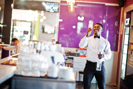 African american bartender at bar flair in action, working behind the cocktail bar. Alcoholic beverage preparation.の写真素材