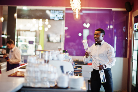 African american bartender at bar flair in action, working behind the cocktail bar. Alcoholic...