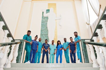 Group of african medical students in college standing on stairs.