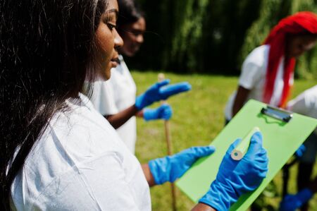 Happy african volunteer woman hold clipboard. Africa volunteering, charity, people and ecology concept.の写真素材