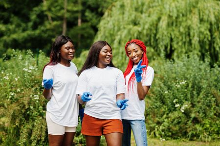 Three african volunteer womans in park. Africa volunteering, charity, people and ecology concept.の写真素材