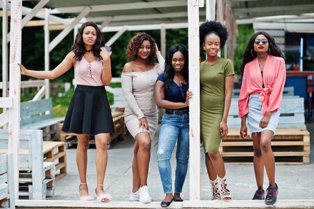 Group of five african american girls relaxing at beach outside cafe.の写真素材