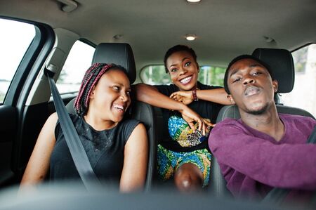 Young african american friends sitting inside a car.の写真素材