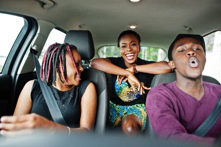 Young african american friends sitting inside a car.の写真素材