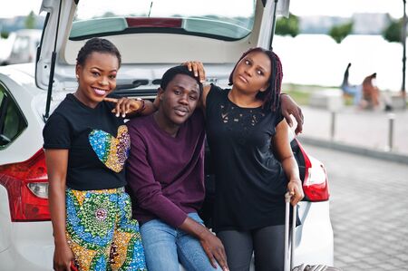 Three african american friends sit in the trunk of the car.の写真素材