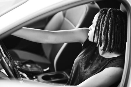 Portrait of young african american woman driving a car.