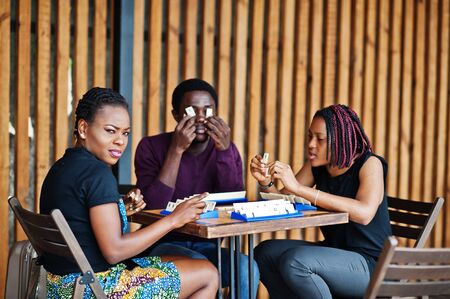 Group of three african american friends play table games.の写真素材