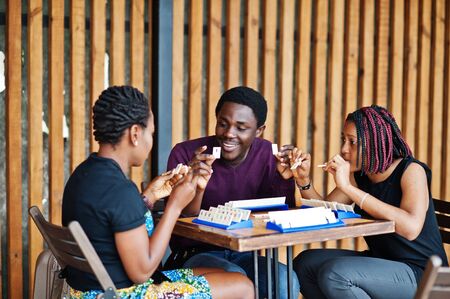 Group of three african american friends play table games.の写真素材