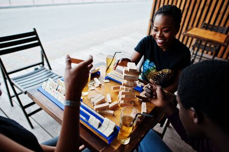 Group of three african american friends play table games.の写真素材