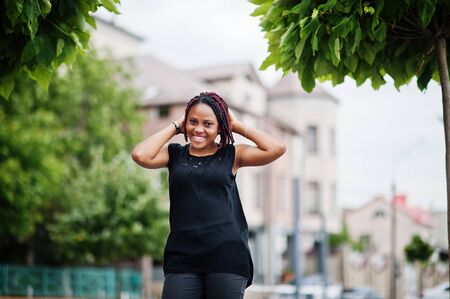 Young african american woman posed against fountain.