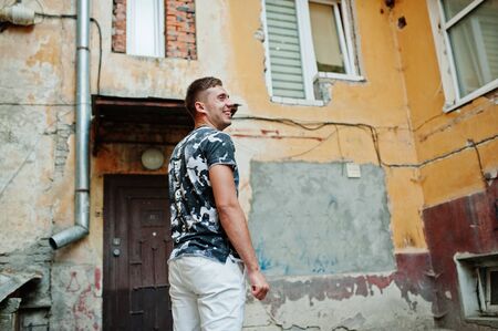 Lifestyle portrait of handsome man posing in the city in the old courtyard.の写真素材