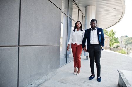 Stylish african american couple in formal wear walking with holding hands together. Romantic couple in love dating.の写真素材