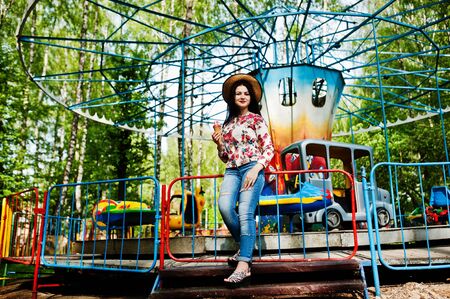 Brunette girl with ice cream in the amusement park.の写真素材