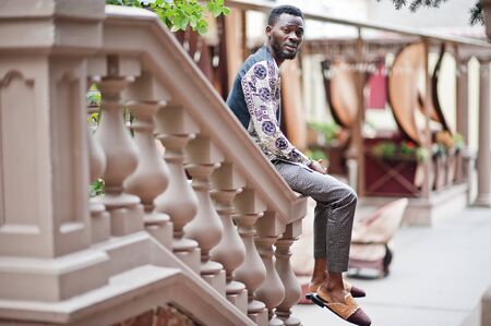 Handsome afro american man wearing traditional clothes in modern city.