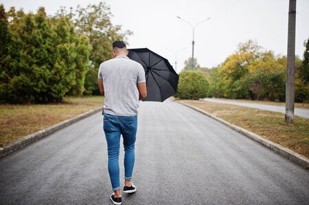 Back of fashionable tall arab beard man wear on shirt, jeans and sunglasses walking at park with...
