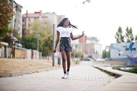 African american dark skinned slim model posed in a black leather shorts and white t-shirt.の写真素材
