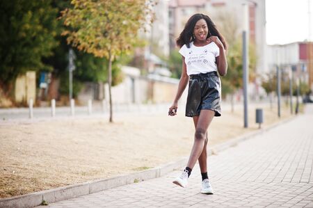 African american dark skinned slim model posed in a black leather shorts and white t-shirt.の写真素材