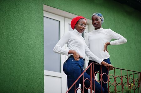 Two young modern fashionable, attractive, tall and slim african muslim womans in hijab or turban head scarf posed together.の写真素材
