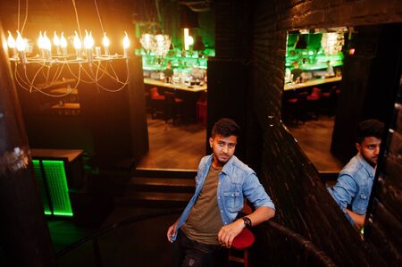 Portrait of handsome successful bearded south asian, young indian freelancer in blue jeans shirt...