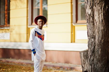 Stylish trendy afro france man in red hat and white outfit posed at autumn day. Black african model guy.の写真素材