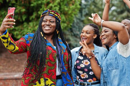 Group of five african college students spending time together on campus at university yard. Black...