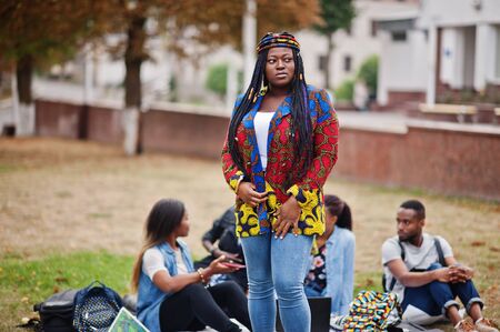 Group of five african college students spending time together on campus at university yard. Black afro friends studying. Education theme.の写真素材