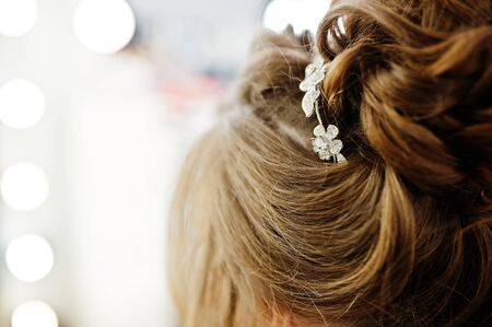 Morning of the bride preparation. Young and handsome bride at wedding day. Hairpin in the headの写真素材