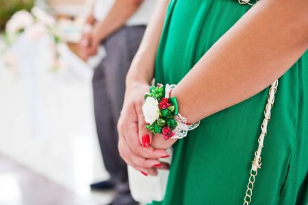 Hands of bridesmaid on green dress at wedding.の写真素材