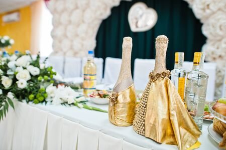 Beautiful wedding set decoration in the restaurant. Bottles of champagne in table of newlyweds.の写真素材
