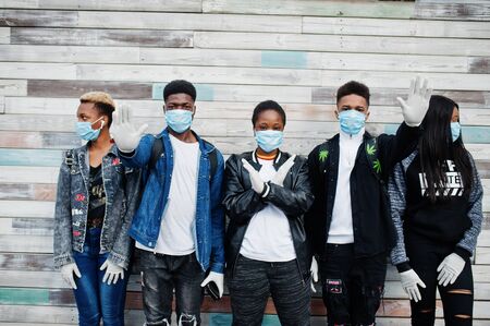 Group of african teenagers friends wearing medical masks protect from infections and diseases coronavirus virus quarantine.の写真素材