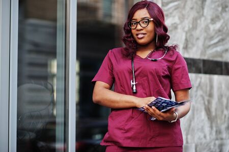 African american female doctor at red lab uniform with stethoscope. Medicine, profession and healthcare concept.の写真素材