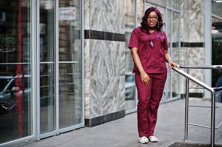 African american female doctor at red lab uniform with stethoscope. Medicine, profession and healthcare concept.の写真素材