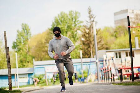 Portrait sports arabian man in black medical face mask run outdoor during coronavirus quarantine.