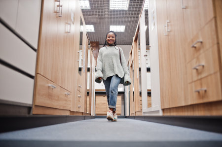 African woman choosing the right furniture for her apartment in a modern home furnishings store.の写真素材