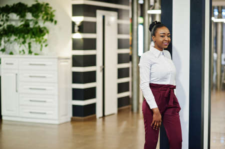 Charming african american woman in formal wear posing at restaurant.の写真素材