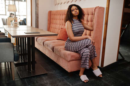 Ð¡harming elegant young african american woman with long curly hair wearing jumpsuit posing at...