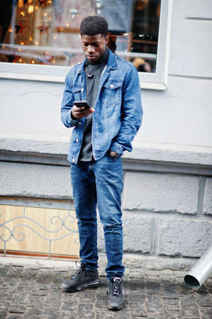 African man wear on black hat posed outdoor against business car.