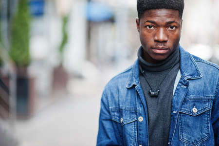 African man wear on black hat posed outdoor against business car.の写真素材