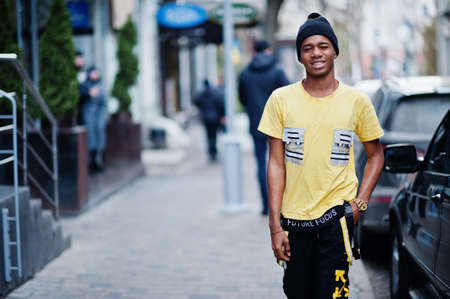 African man wear on black hat posed outdoor against business car.
