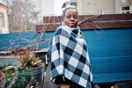 African woman in checkered cape posed outdoor.の写真素材