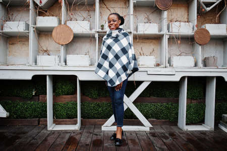 African woman in checkered cape and eyeglasses posed outdoor.の写真素材