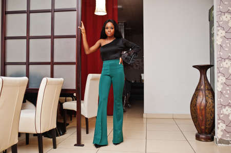Beauty slim african american model wear on black blouse and green long legs pants posed at chinese...