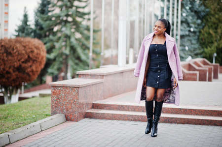Young stylish beautiful african american woman in street, wearing fashion outfit coat.