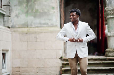 Thoughtful young handsome african american gentleman in formalwear. Black stylish model man in white...