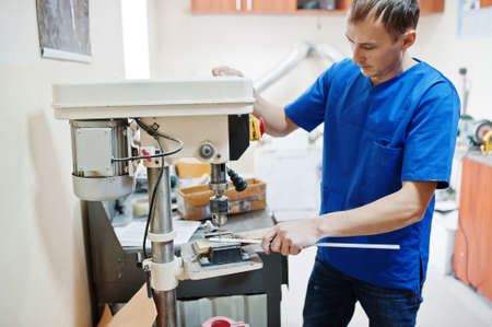 Prosthetist man making prosthetic leg while working in laboratory.