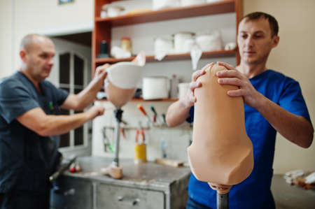 Two prosthetist man workers making prosthetic leg while working in laboratory.の写真素材