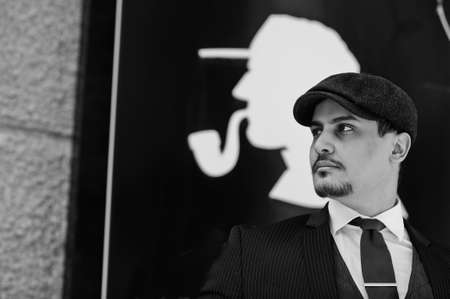 Portrait of retro 1920s english arabian business man wearing dark suit, tie and flat cap.の写真素材